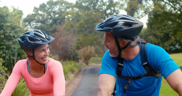 Couple interacting face to face while riding bicycle