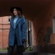 Young Redhead Woman in a Blue Coat and Black Hat with a Suitcase on the Background of the Old City - VideoHive Item for Sale