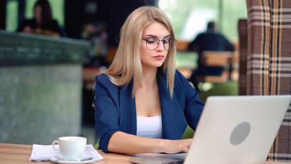 Confident Beautiful Young Business Female Working in Cafe Looking at Screen of Laptop