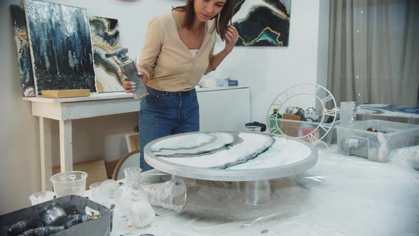 Young Woman Using a Burner on the Surface of Epoxy Resin Painting in Art Studio