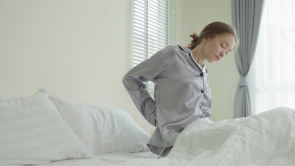 Caucasian beautiful sick girl in pajamas get up from sleep in bedroom.