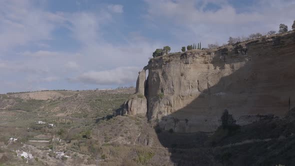 Aerial approaches nearly detached limestone pillar below Ronda, Spain