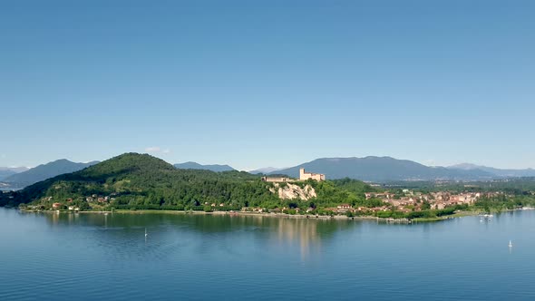 Timelapse of Maggiore lake withing clouds over boats sailing and Angera castle, Italy