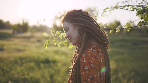 Portrait of an Beautiful Hippie Woman with Dreadlocks in the Woods at Sunset Having Good Time