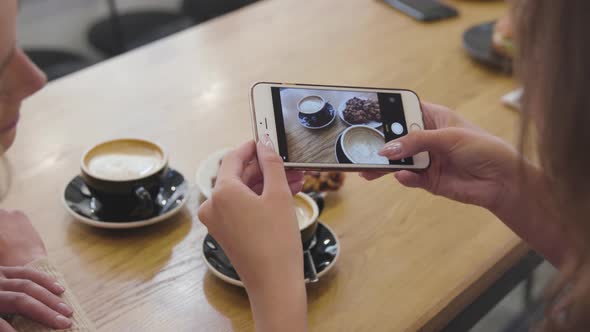 Woman hands taking food photo on mobile phone at cafe closeup. 