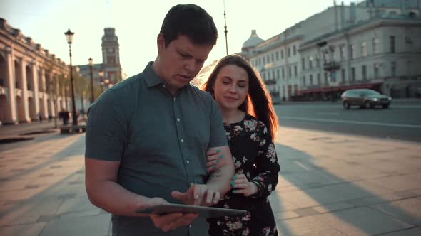 Man and Woman Use Digital Pad Device for Navigation