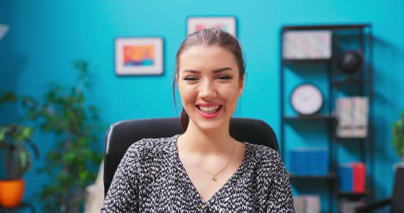 Smiling Young Woman Chats on Video Chat on Laptop