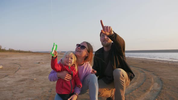 Happy Family with Flying Kite at the Seashore During Sunset Slow Motion