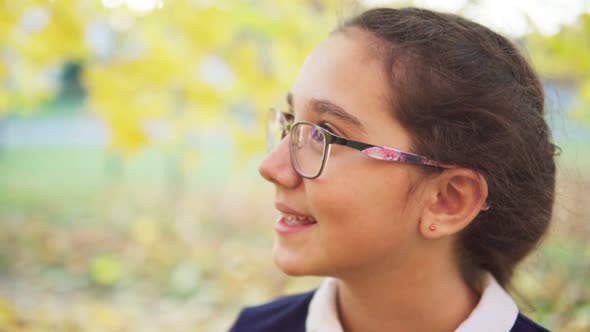 Beautiful Teenage Girl Looking Away in Autumn Park