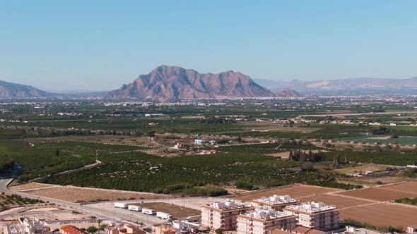 Buildings, Green Citrus Farm Fields, And Mediterranean Mountainscape Near Algorfa, Spain.