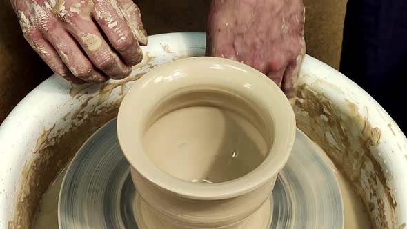 The Men Potter's Hands Form By a Clay Pot on a Potter's Wheel