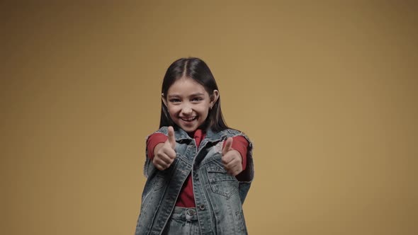 Portrait of Little Girl Giving Thumbs Up to the Camera Smiling Happy Emotions