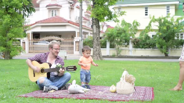 Portrait of Happy Multi-ethnic Family Bonding Together with Music Outdoors