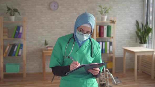 Close Up Portrait of a Female Doctor Is a Muslim Woman with a Folder