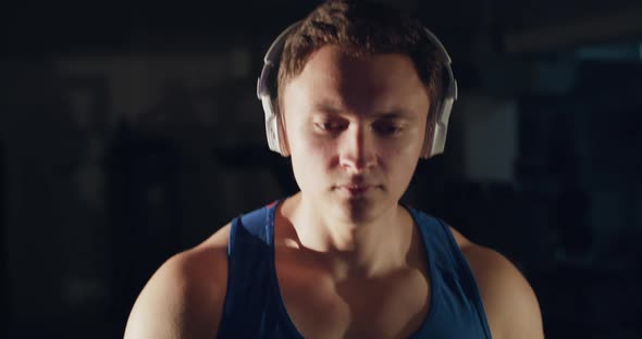 Close View of Confident Sportsman with Headphones is Going on a Treadmill in Gym