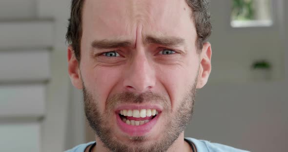 Headshot Portrait of a Young Caucasian Bearded Man Taking Off His Glasses for Vision and Expressing