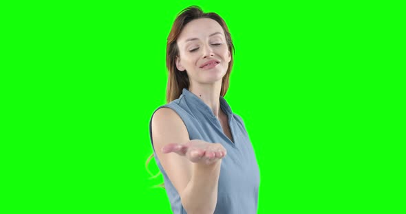 Caucasian woman raising hand on green background