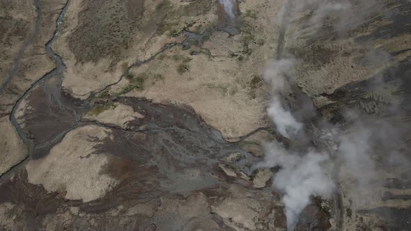 Reykjadalur fumarole in Iceland and surrounding landscape. Aerial top down forward