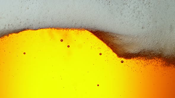 Super Slow Motion Detail Shot of Rippling Beer Bubbles and Foam in Glass at 1000Fps