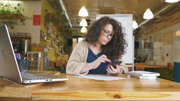 Young Happy Woman Working in the Office Writing Something and Using Computer