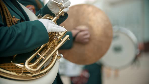 A Wind Instrument Military Parade - a Man in Green Costume Playing French Horn Outdoors