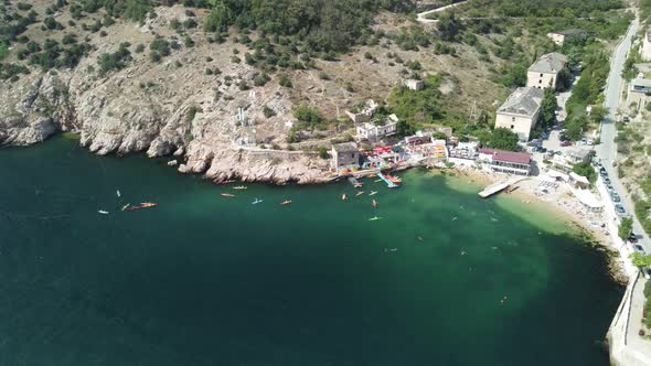 Aerial Drone View on Colorful Kayaks Grouped at a Dock in Sea Bay