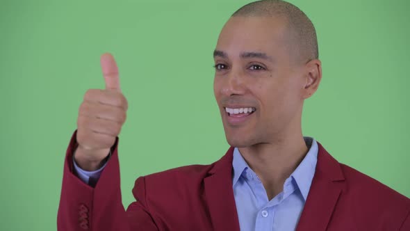 Face of Happy Bald Multi Ethnic Businessman Giving Thumbs Up