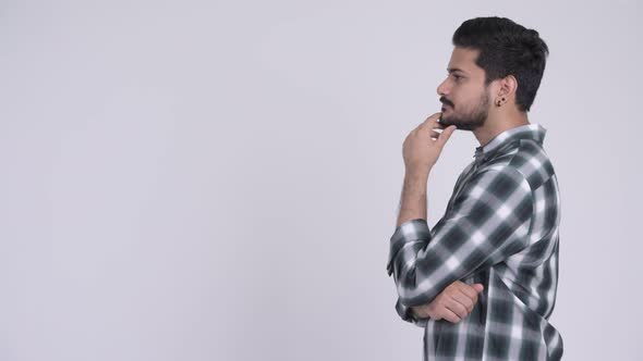 Profile View of Young Happy Bearded Indian Man Thinking