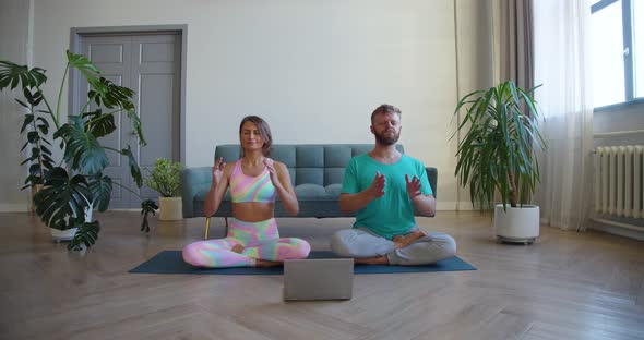 Couple Meditating at Home with Online Yoga Tutorial