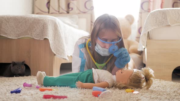 Beautiful Little Girl Playing Doctors with Doll at Home