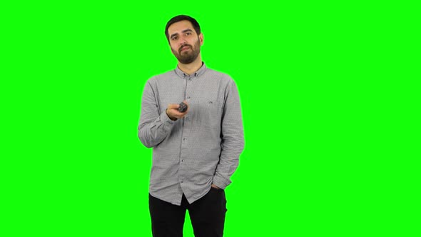 Brunette Guy with TV Remote in His Hand, Switching on TV. Green Screen