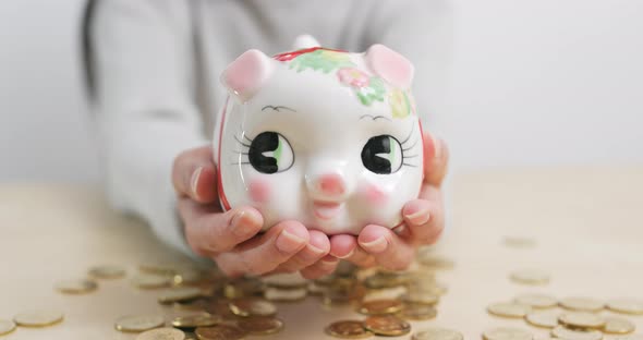 Woman putting coins into piggy bank