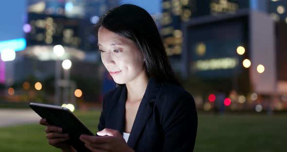 Business woman use of tablet computer at night