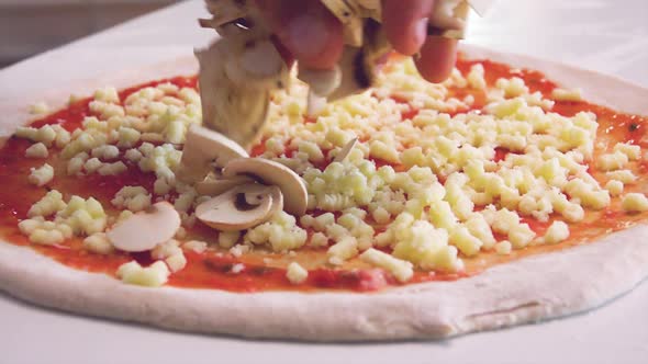 Cook preparing pizza with mushrooms