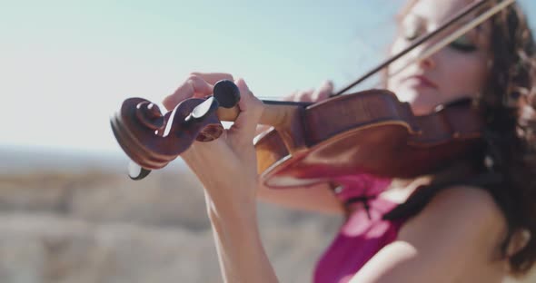 Close View of Two Female Violinists in Dresses Play Instrumental Music at Rocks