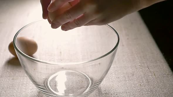 Breaking eggs to glass bowl. Cooking. Slow motion