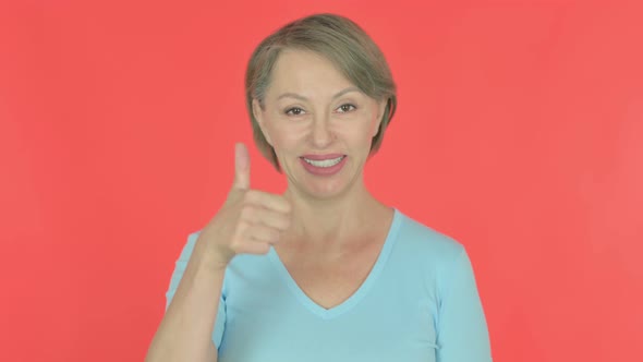 Thumbs Up By Old Woman on Red Background