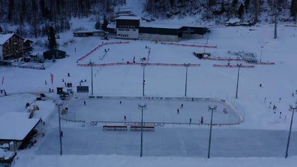 Aerial of people playing ice hockey in hockey rink in snow covered landscape