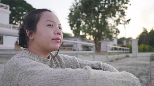 Asian woman sitting and getting good weather by the river