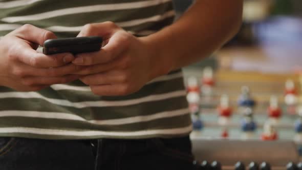 Mixed race man using his phone in his house