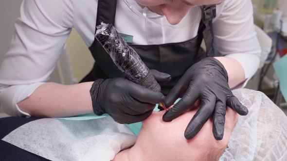 Cosmetologist Makes Permanent Makeup Lips Procedure Applying Pigment Makeup on Lips with Tattoo