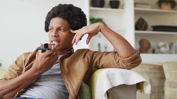 African american man using smartphone at home