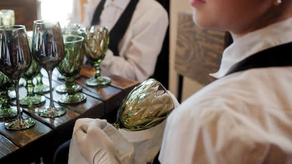 Female Hands of Waitress Wiping Wine Glass in Cafe