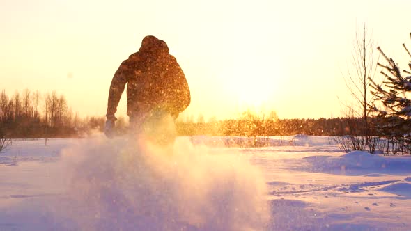 Silhouetted Man Running Through Snow in Winter Landscape