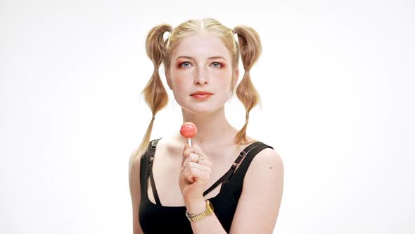 Young Beautiful Girl Dancing Smiling Holding Chupa Chups Over White Background