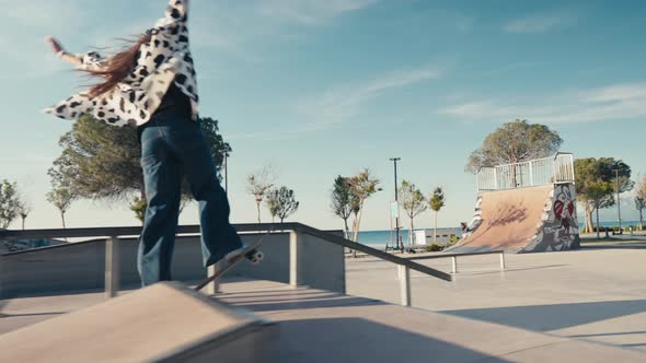 Young Woman Skateboarding Carving the Bowl at the Park