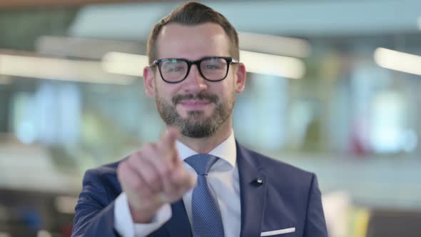 Portrait of Middle Aged Businessman Pointing at Camera Inviting