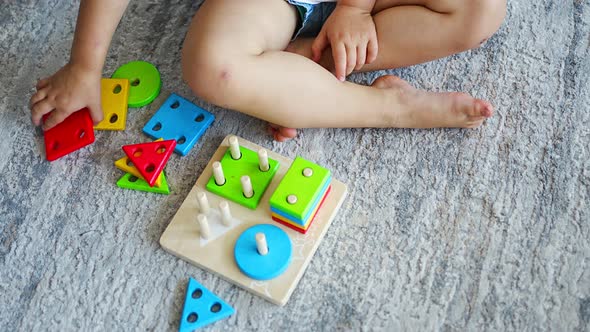 Cute Caucasian Little Girl Playing on the Floor at Home with Eco Wooden Toys