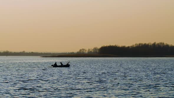 Boat with Fishermen at the River at Sunset