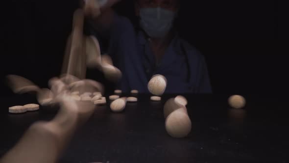 Doctor Hand Throws Light Pills Onto Black Surface Closeup